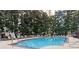 A beautiful outdoor swimming pool surrounded by lush trees and lounge chairs at 1101 Juniper Ne St # 415, Atlanta, GA 30309