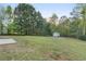 Large backyard with a storage shed on the property and trees, offering ample space and privacy at 175 Cypress Dr, Covington, GA 30016