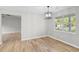 Bright dining room with wood floors, modern lighting fixture, and large windows offering outdoor views at 175 Cypress Dr, Covington, GA 30016