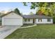 Charming single-story home featuring a manicured lawn, attached garage, and classic vinyl siding at 175 Cypress Dr, Covington, GA 30016
