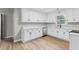 Well-lit kitchen featuring white cabinets, granite countertops, stainless steel appliances, and wood flooring at 175 Cypress Dr, Covington, GA 30016
