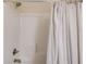 Enclosed white tiled shower featuring updated shower head and fixtures and a textured curtain at 2042 Clay Rd, Snellville, GA 30078