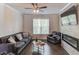 A cozy living room with a fireplace, hardwood floors, large windows, a ceiling fan, and neutral paint at 2042 Clay Rd, Snellville, GA 30078