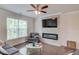 A cozy living room with a fireplace, hardwood floors, large windows, a ceiling fan, and neutral paint at 2042 Clay Rd, Snellville, GA 30078
