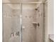 Enclosed shower with stone patterned tile and built-in soap and shampoo nook at 2042 Clay Rd, Snellville, GA 30078