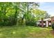 Spacious backyard with a well-manicured lawn, mature trees, and a glimpse of the home's exterior at 3228 Clairmont North Ne # 3228-A, Brookhaven, GA 30329