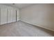 Neutral bedroom featuring plush carpet, double door closets, and a bright white door at 6413 Swift Creek Dr, Lithonia, GA 30058