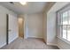 Carpeted bedroom with closet, window, and access to an adjoining room at 6413 Swift Creek Dr, Lithonia, GA 30058