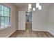 Charming dining space with a modern chandelier and ample natural light from the window at 6413 Swift Creek Dr, Lithonia, GA 30058
