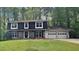 Charming two-story home with stone accents, a two-car garage, and a well-maintained lawn at 6413 Swift Creek Dr, Lithonia, GA 30058