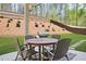 Backyard patio area with a round table, chairs, and BBQ grill at 6917 Demeter Dr, Atlanta, GA 30349