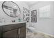 Neutral bathroom offers framed art, a round mirror, and wooden-look tile flooring at 6917 Demeter Dr, Atlanta, GA 30349