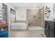 Bright bathroom featuring a walk-in shower, soaking tub, and a vanity area with ample storage and natural light at 6917 Demeter Dr, Atlanta, GA 30349