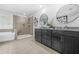 The bathroom showcases a glass-enclosed shower, dual vanities with stone countertops, and a soaking tub for spa days at 6917 Demeter Dr, Atlanta, GA 30349