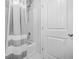 Bright bathroom features a shower, shower curtain, and a white paneled door at 6917 Demeter Dr, Atlanta, GA 30349