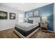 Stylish bedroom showcasing a platform bed and blue accent wall with modern artwork at 6917 Demeter Dr, Atlanta, GA 30349