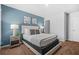 Stylish bedroom showcasing a platform bed and blue accent wall with modern artwork at 6917 Demeter Dr, Atlanta, GA 30349