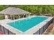 Fenced community pool surrounded by lounging area and lush greenery, offering a refreshing retreat at 6917 Demeter Dr, Atlanta, GA 30349