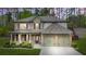 Beautiful two-story home with stone and brick accents, complemented by a well-manicured front yard and two-car garage at 6917 Demeter Dr, Atlanta, GA 30349