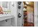 Bathroom sink with decorative wall baskets and shelving unit behind door at 1015 S Candler St, Decatur, GA 30030