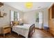 Charming bedroom featuring hardwood floors, two windows, and stylish light fixture at 1015 S Candler St, Decatur, GA 30030