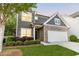 Two-story home featuring dark siding, brick accents, attached garage and landscaped yard at 3314 Tiara Cir, Atlanta, GA 30311