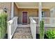 Welcoming front porch with brick stairs, white railings, and neatly trimmed shrubs at 4349 Northmark Ln, Buford, GA 30518