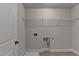 Laundry room with washer and dryer hookups, storage rack, and tile flooring at 4349 Northmark Ln, Buford, GA 30518