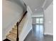 Hallway with a staircase featuring carpeted steps, hardwood floors, white walls, and lots of natural light at 4349 Northmark Ln, Buford, GA 30518