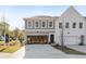 Modern townhome exterior with gray and white brick, a garage, and professional landscaping at 440 Carrera Ln, Acworth, GA 30102