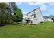Backyard with large lawn, mature trees, wood deck, and a two-story home in a neighborhood at 131 Magazine St, Dallas, GA 30157
