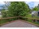 Wood deck with black metal railing offers views of a beautiful yard with mature trees at 131 Magazine St, Dallas, GA 30157