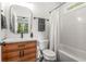 Bathroom with wooden vanity, white tiled walls and a bathtub with shower at 2537 Thompson Ne Rd, Brookhaven, GA 30319