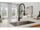Close-up of a sleek, modern kitchen sink and faucet with natural light from nearby windows at 432 Carrera Ln, Acworth, GA 30102