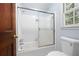 Bathroom with a shower/tub combination, sliding glass door, toilet, and white tile at 4140 Westchester Ne Xing, Roswell, GA 30075