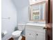 Powder room featuring a toilet, a sink with white vanity, a mirror, and light-blue paint at 4140 Westchester Ne Xing, Roswell, GA 30075
