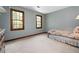 Bedroom with light blue walls, carpet, and two windows looking onto trees at 4140 Westchester Ne Xing, Roswell, GA 30075