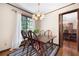 Dining room with wood table and chairs, chandelier, striped rug, and view of wooded area at 4140 Westchester Ne Xing, Roswell, GA 30075