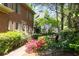A brick home featuring meticulously manicured landscaping with vibrant flowers and a serene outdoor seating area at 4140 Westchester Ne Xing, Roswell, GA 30075