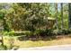 Landscaped lawn and a stately brick home partially obscured by a large Magnolia tree at 4140 Westchester Ne Xing, Roswell, GA 30075