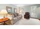 Bright living room with neutral carpet, a comfortable patterned sofa, leather chair, side table, and large windows at 4140 Westchester Ne Xing, Roswell, GA 30075