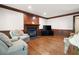 Cozy living room features a fireplace with wood trim, hardwood floors, comfortable seating, and a wall-mounted TV at 4140 Westchester Ne Xing, Roswell, GA 30075