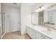 Bathroom featuring dual sinks, framed mirror, shower and a separate tub in the background at 5450 Fieldfreen Dr, Cumming, GA 30028