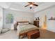 Bright bedroom features a ceiling fan, tray ceiling, and natural light from the window at 5450 Fieldfreen Dr, Cumming, GA 30028