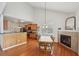 Open concept space with a fireplace, breakfast table, and a view to the kitchen with modern appliances at 5450 Fieldfreen Dr, Cumming, GA 30028