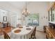 Traditional dining room with a large oval table, classic chandelier, and natural light from a large window at 5450 Fieldfreen Dr, Cumming, GA 30028