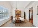 Charming dining area features a traditional table set beneath an elegant chandelier and bright natural light at 5450 Fieldfreen Dr, Cumming, GA 30028
