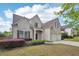 Charming brick home featuring a well-maintained lawn and two-car garage at 5450 Fieldfreen Dr, Cumming, GA 30028