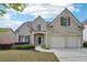 Charming two-story brick home featuring a two-car garage, landscaped yard and inviting front entrance at 5450 Fieldfreen Dr, Cumming, GA 30028