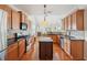 Modern kitchen with stainless steel appliances, wood cabinetry, and an island, offering both style and functionality at 5450 Fieldfreen Dr, Cumming, GA 30028